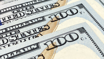 Several $100 bills are in close-up. Hundred-dollar bills. The American national currency. Economics...