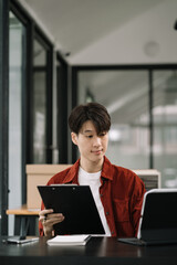 BBusinessman using laptop computer with documents in office. Happy man, entrepreneur, small business owner working online.