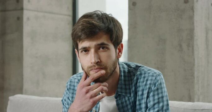 Video chat with young Caucasian man. Young man has online business conference call. Man nods listens keeps silent. Webcam view portrait. Nods head yes answers positive agreement approval support agree