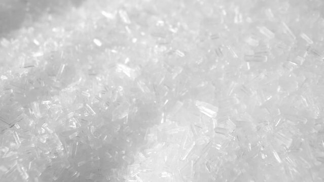 Monosodium glutamate (MSG) is a flavor enhancer commonly used in food. In a macro video, explore its fine, crystal-like structure and watch as it dissolves into a savory delight. Food background.
