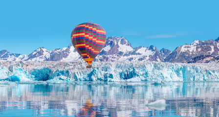 Hot air balloon flying over Knud Rasmussen Glacier near Kulusuk - Greenland, East Greenland - obrazy, fototapety, plakaty