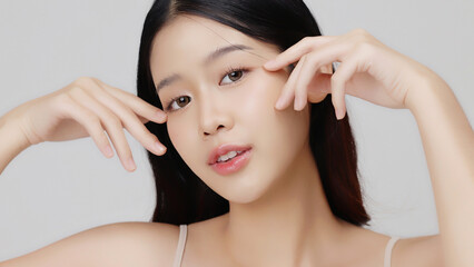 Young beauty Asian girl with Korean makeup style touch her face gently on isolated background....