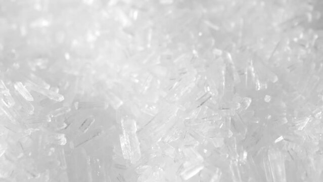 Macro video of Monosodium glutamate (MSG), a flavor enhancer used in food, reveals its tiny crystal structure. This white, odorless powder adds umami taste to dishes, captivating taste buds worldwide.