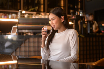 A young woman drinking coffee in modern coffee shop