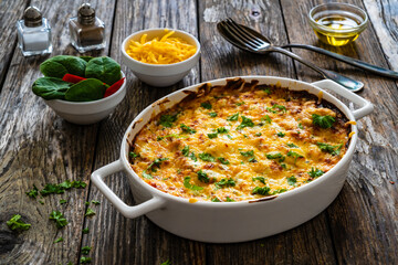 Potato casserole with mozzarella cheese and bechamel sauce on wooden table
