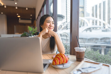 Happy smile asian woman relax at cafe with laptop sitting near window indoors on day city people...
