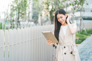 Fototapeta premium Freelance young asian woman walking with travel luggage for business trip