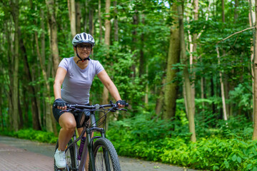 Fototapeta premium Woman riding bicycle in forest 