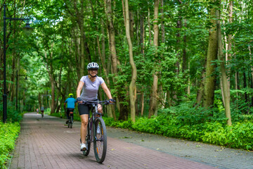 Woman riding bicycle in forest
