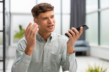 Handsome businessman in office using smartphone.