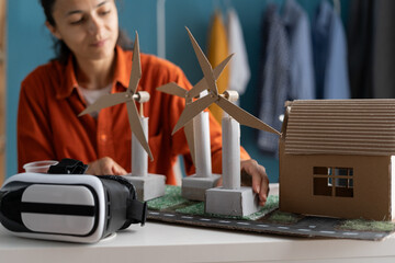 woman doing science project at home office using windmills as alternative energy