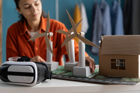 woman doing science project at home office using windmills as alternative energy