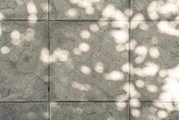 Duppled floral sun light shadow on terrace tile texture. Aesthetic lifestyle paving slab at courtyard
