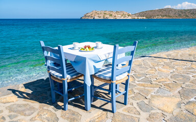 Crete Greece Plaka Lassithi, a traditional blue table and chairs on the beach in Crete Greece....