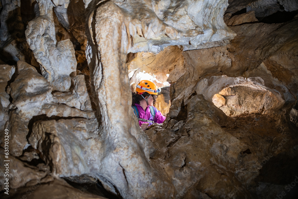 Wall mural young woman spelunking inside a cave. feminism concept. concept of women's sport.