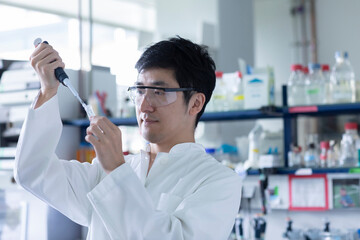 young scientist male chinese working in laboratory
