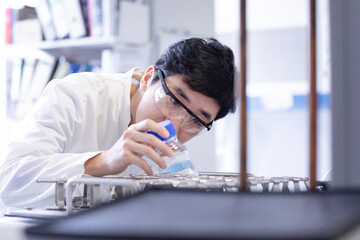 young scientist male chinese working in laboratory