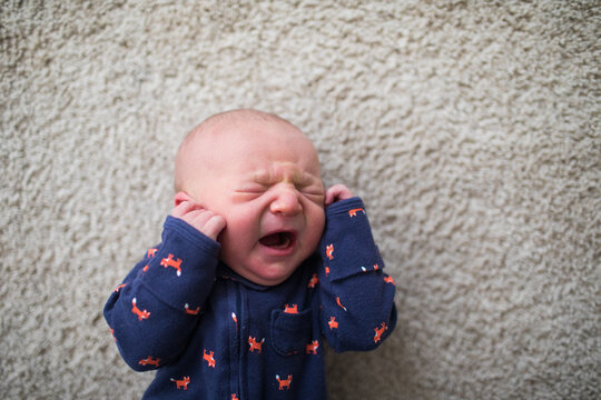 top view of Newborn baby crying on the floor