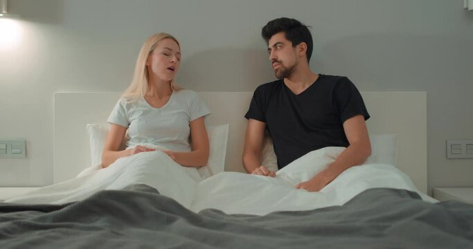 emotional nervous girlfriend scolding, raising voice, screaming at young man. Young couple quarrelling yelling at home. Concept of family problems. Blonde girl leaves guy alone in bedroom Slow motion