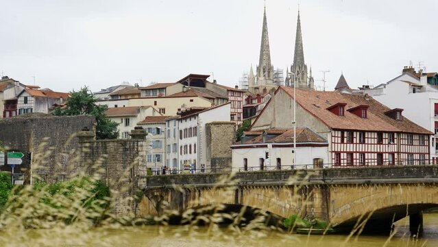 View of the city of Bayonne next to the river that crosses the city and its cathedral emerging between the buildings, France.