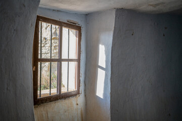 Fototapeta na wymiar Abandoned Argueda caves view of the window with white walls, in Spain