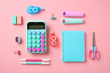 Back to school concept. School supplies on pastel pink background. Flat lay, top view calculator, paper notebook, scissors, pens, sharpeners, erasers, markers