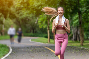 young woman exercising Young woman jogging in morning exercise, soft sunlight at park