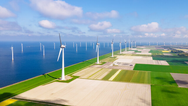 Windmill park with clouds and a blue sky, windmill park in the ocean drone aerial view with wind turbine Flevoland Netherlands Ijsselmeer. Green Energy in the Netherlands