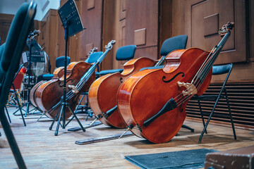 Classical musical instruments on stage. Orchestra pit, double basses, sheet music, opera house. Stringed instruments. Classical music concert.