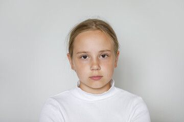 Serious child girl on white background, studio portrait