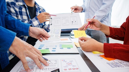 Close-up ux developers and ui designers use augmented reality to brainstorm on mobile app interface...