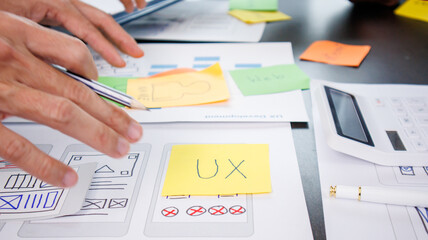 Close-up ux developers and ui designers use augmented reality to brainstorm on mobile app interface...