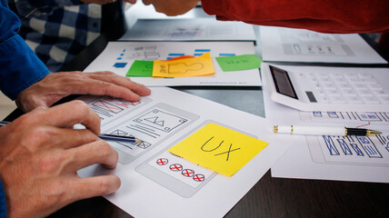 Close-up ux developers and ui designers use augmented reality to brainstorm on mobile app interface...
