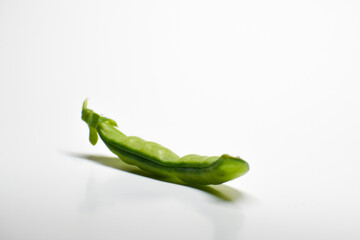A pod of green peas on a white background. Delicious sweet vegetable close-up.