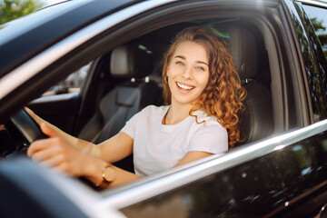 Stylish woman driving a car. The traveler is the driver. Automobile travel. Sharing a car. Lifestyle concept.