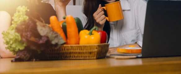 Happy two young women looking laptop computer during cooking together in kitchen room at home. Two young diverse lesbian women spending time together. LGBT and gender identity concept..