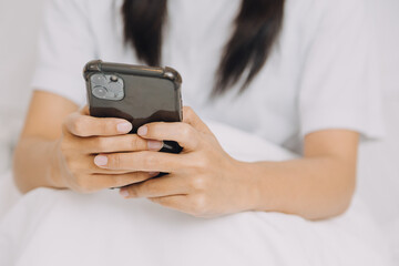 Young adult happy smiling Hispanic Asian student wearing headphones talking on online chat meeting using laptop in university campus or at virtual office. College female student learning remotely.