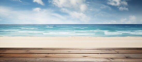 Fototapeta premium A wooden table or pier is shown in the presence of a sunny beach and sea in the background. provides an ample amount of space for featuring and promoting your product.