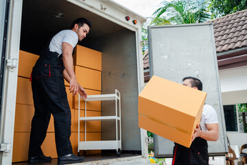 Unloading boxes and furniture from a pickup truck to a new house with service cargo two men movers...