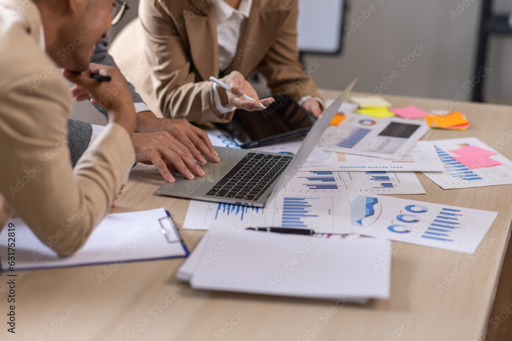 Wall mural Group of confident business people point to graphs and charts to analyze market data, balance sheet, account, net profit to plan new sales strategies to increase production capacity.	