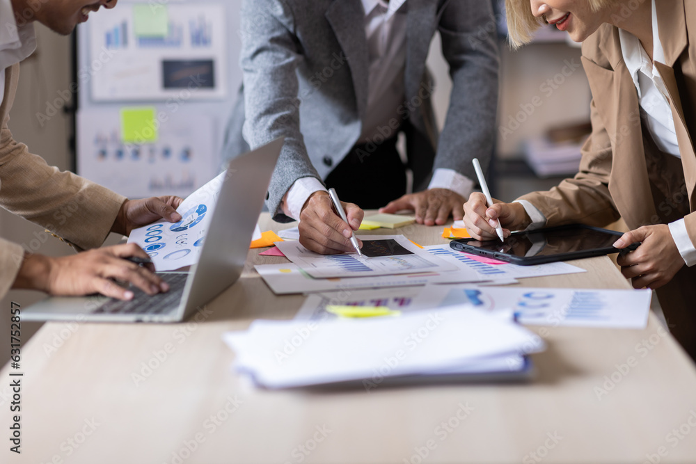 Wall mural Group of confident business people point to graphs and charts to analyze market data, balance sheet, account, net profit to plan new sales strategies to increase production capacity.	