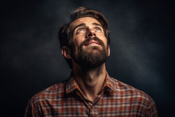 Facet portrait a man looking up, Dark lighting portrait bristle men in checkered shirt looks up with his head up on a dark gray background copy space
