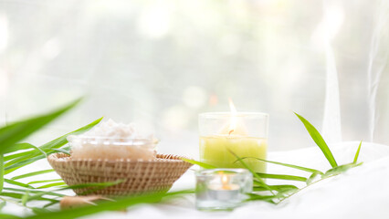 Obraz na płótnie Canvas Thai Spa Treatments aroma therapy salt and sugar scrub massage with bamboo leaves with candle, white background. Thailand. Healthy Concept