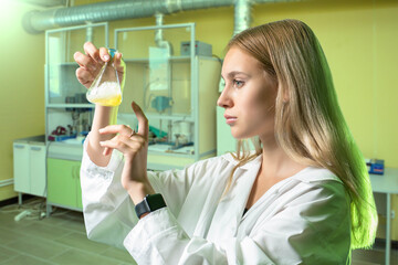 Woman chemist. Student in laboratory. Chemist girl holding flask. Young woman is studying...