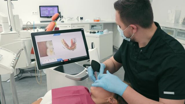 Dentist scans the patient's teeth using the CEREC scanner. Modern dentistry. The dentist uses a 3D dental intraoral scanner to scan the patient's teeth