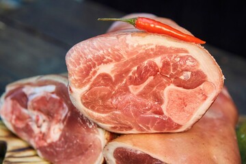 A piece of raw meat and spices lie on a wooden cutting board. Raw food for cooking.