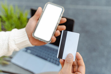 Close up of business man hand holding credit card using mobile phone shopping online, selective focus. Mockup. Technology concept
