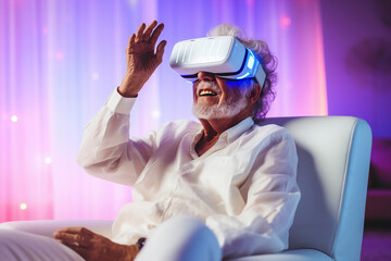Caucasian elderly man is sitting in an armchair in the living room with neon illumination, wearing virtual reality glasses, and smiling.