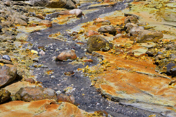 Sulphuric water stream with sulfur in the crater area of Whakaari, White Island volcano in new Zealand