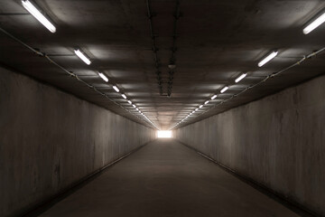 underground concrete tunnel and exit light at the destination
